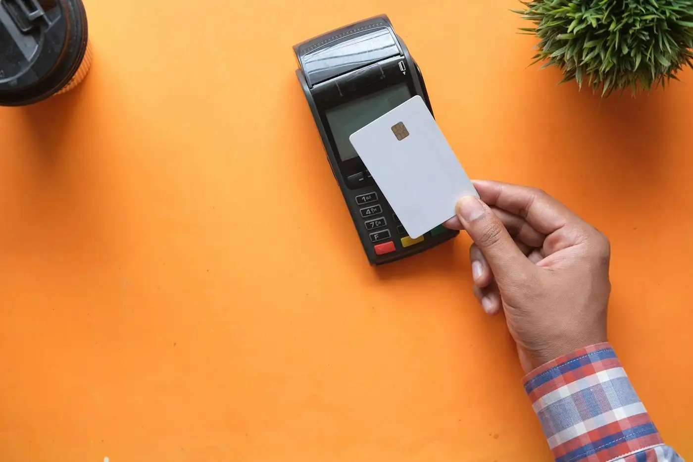 A card held up to a countertop payment terminal