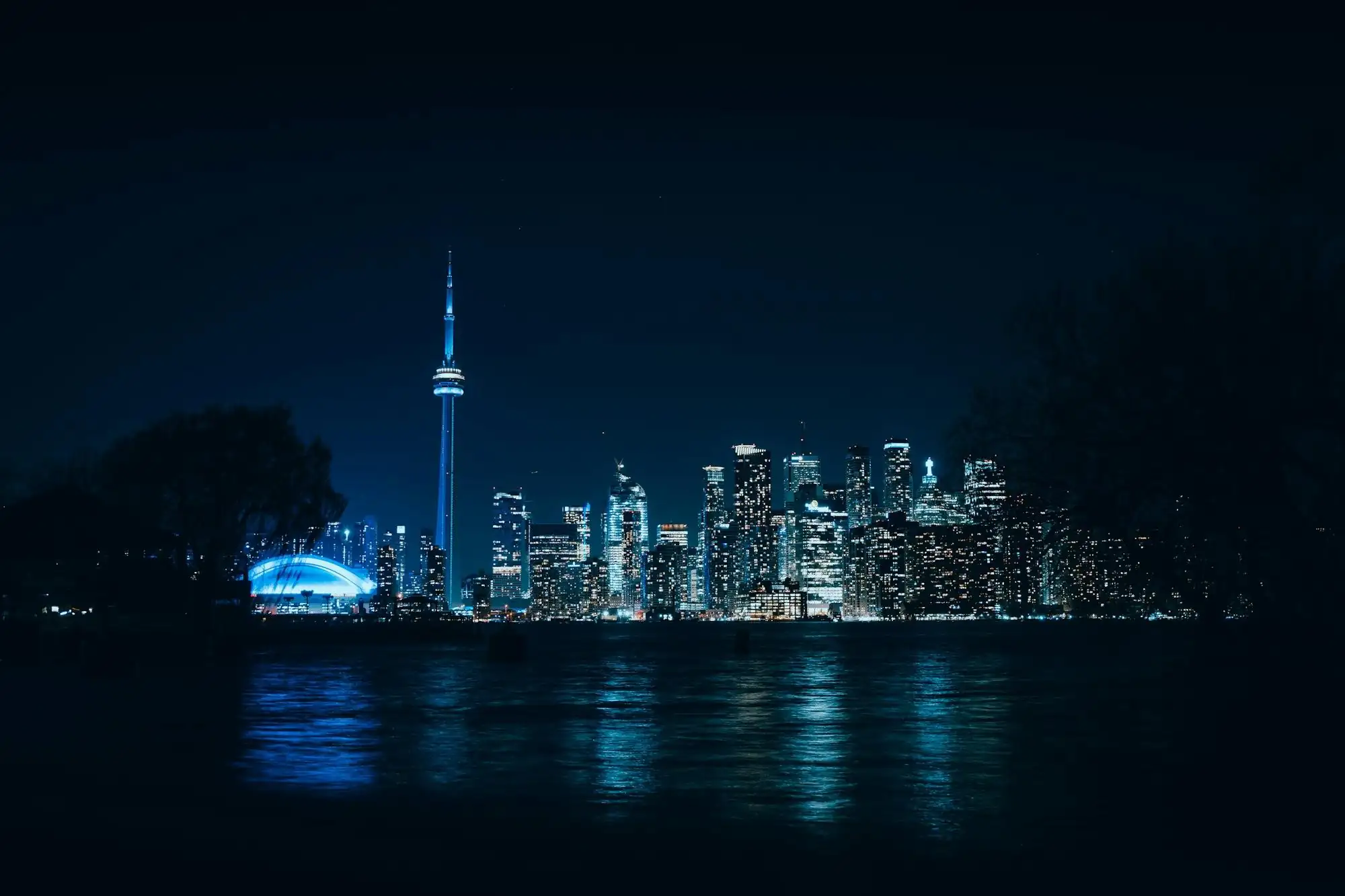 The Toronto skyline lit up at night, seen across the water